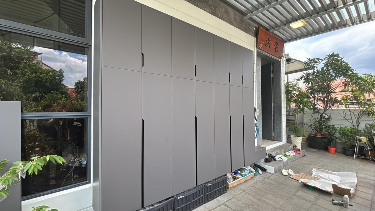 Floor-to-ceiling grey aluminium storage cabinets along a covered porch