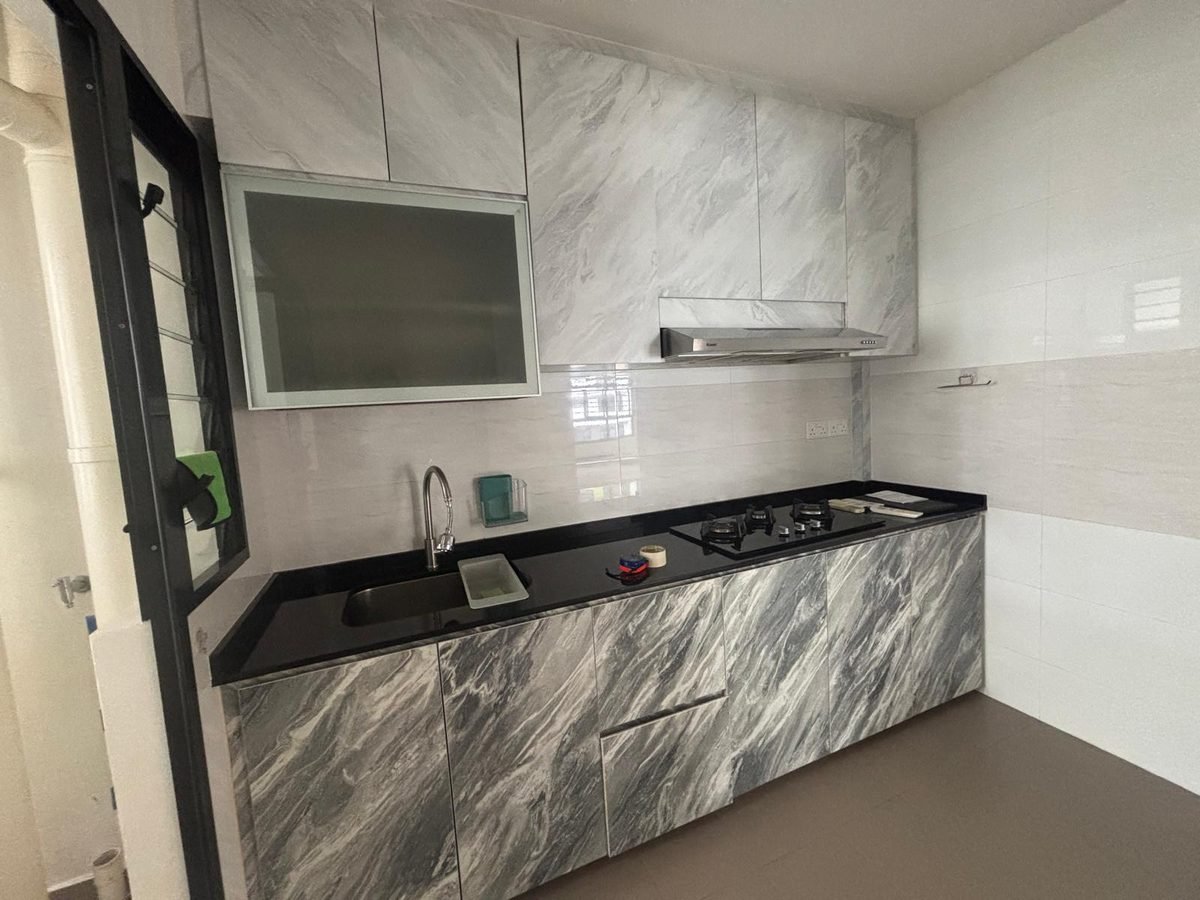 Aluminium kitchen cabinets with marble-pattern lower doors and black countertop